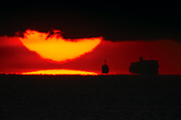 海から離れて雲に入る日の出の太陽20220101