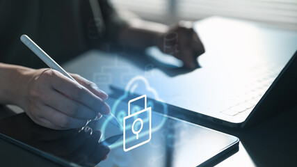 Hand using stylus on digital tablet with padlock icon, representing cloud security, secure access, data protection, encryption, and cybersecurity system in modern enterprise technology.