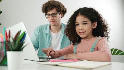 American student looking at camera while working on laptop with dad sitting and looking at laptop screen to check engineering code. Happy school girl smiling while study about generate ai. Pedagogy. - Powered by Adobe