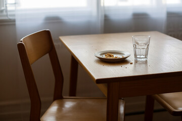 Quiet Dining Table Scene with Plate Crumbs and Soft Afternoon Natural Light
