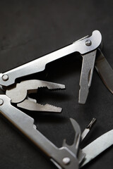 Close-Up of Multifunctional Metal Multitool with Pliers on Dark Background