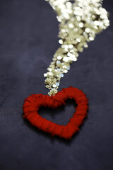 Golden Sequins Pouring onto Red Heart Shape on Dark Background