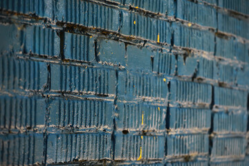 Textured Blue Painted Brick Wall with Vertical Patterns and Subtle Yellow Accents