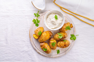 Traditional Swedish dish Hasselback potatoes with  cream cheese dip
