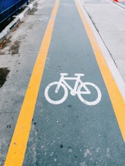 Bicycle lane symbol on urban asphalt path with yellow lines for city infrastructure planning, transportation app development, and eco-friendly micro-mobility design