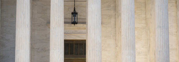 Naklejka premium Government building with timeless columns. Classical facade with massive stone columns. Civic architecture expressed through marble pillars. Historic courthouse with monumental design.