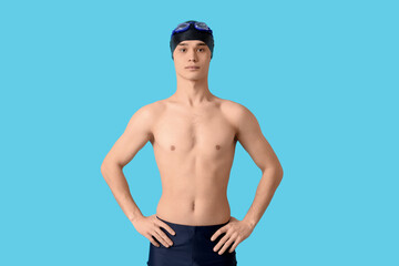 Young male swimmer on blue background