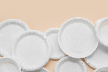 White plastic plates on beige background