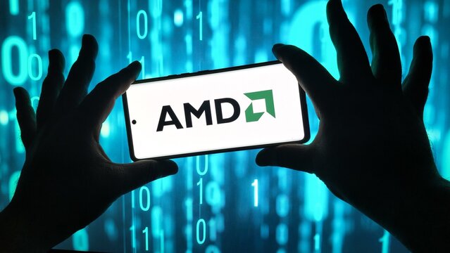 Hands hold smartphone displaying amd logo against binary code