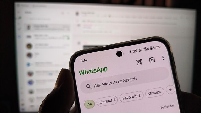 Smartphone displaying whatsapp application interface on a blurred background