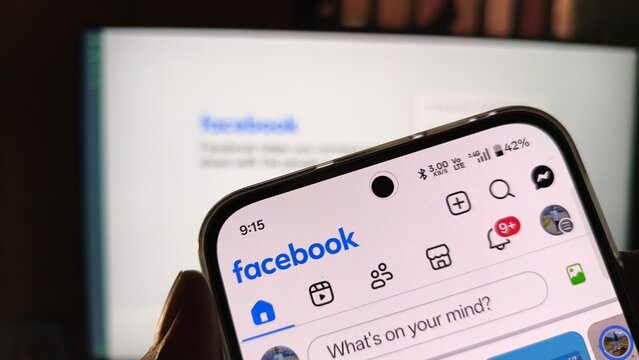 Smartphone showing facebook application interface on a blurred background