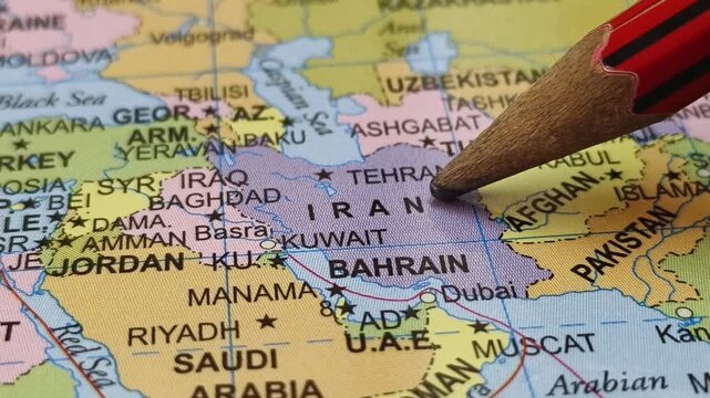 Closeup of pencil tip touching Iran county location or territory mark on a map. Geopolitics and travel tourism creative concept.