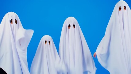 Four figures in white sheets with eye cutouts against a blue background, creating a playful ghostly vibe