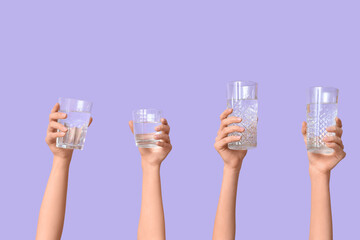 Female hands with different glasses of water on lilac background, closeup