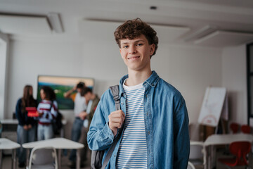 Confident teen student in classroom in school.