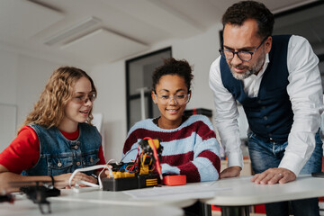 High school students working on robotics project with their teacher. © Halfpoint