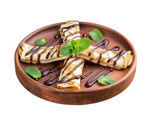 Rolled crepes with chocolate drizzle, mint on a wooden plate (1)