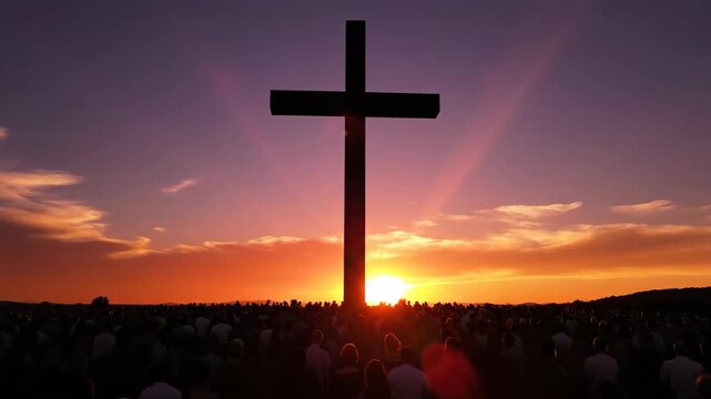 Large crowd gathering in front of a cross at sunset. Religious worship event for christian church service.
