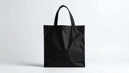 A plain black tote bag against a bright white backdrop
