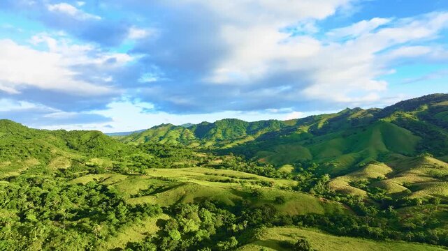 Beautiful nature of the Dominican Republic in the morning light. Mountain peaks rise among the clouds. Large clouds hover above the peaks. A beautiful mountain landscape on the island of Haiti.