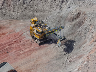Giant electric shovel in the process of extracting and loading silver and gold ores