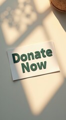 Sign on a table with donate now text