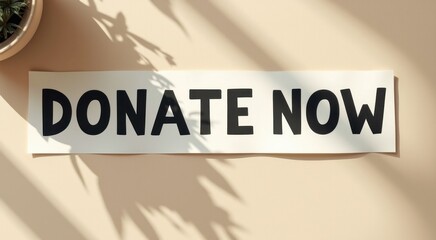 Sign that says donate now on the wall