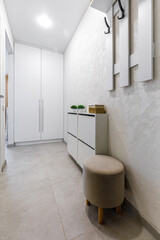 Modern minimalist entryway with white wardrobe and shoe cabinet