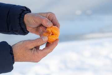 A man feasts on a juicy ripe tangerine.