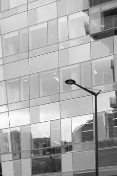Abstract modern corporate architecture building facade of glass windows with street lamppost foreground and quiet empty city corner