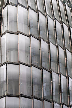 Abstract modern corporate architecture building facade of glass windows with vertical mullions forming a refined geometry pattern and sleek rhythm