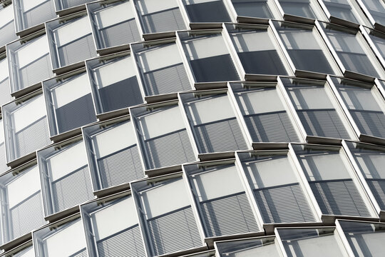 Abstract modern corporate architecture building facade of glass windows in stacked modules creating a sharp geometry pattern texture