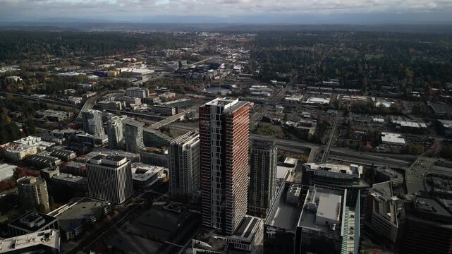 Aerial drone view of downtown showing dense modern skyscrapers and urban grid. Elevated perspective highlights freeway interchange and surrounding commercial district within the city center.