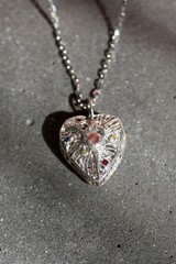 Elegant Handcraft Heart Shaped Pendant with Gemstones on Concrete Background. Jewelry accessories.