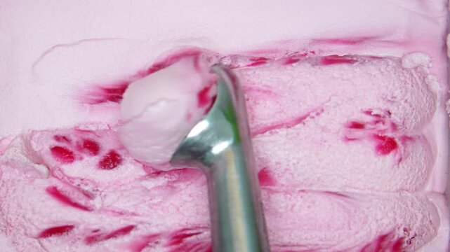 4K Close up detail - Metal spoon Scooping Slow motion ice cream ball strawberry, Top view Food concept.