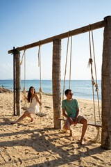 Couple relaxing on beach swing enjoying summer vacation