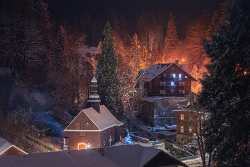 Winter landscape of Miedzygórze village in Poland, covered in fresh snow. Mountain resort in the Sudetes, wooden houses, peaceful winter scenery, cold weather, travel destination.