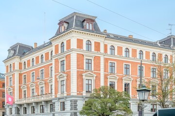 Fototapeta premium Classic European Residential Building with Red Brick Facade and Mansard Roof