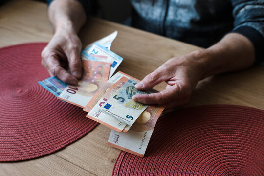 A pensioner counts money, euro banknotes.
