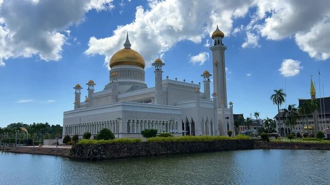 Brunei Darussalam - June 25, 2025: Sultan Omar Ali Saifuddin Mosque in Bandar Seri Begawan. Mosque with reflection in the pond. The mosque's facade and dome are illuminated by sunlight. 4K