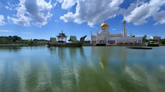 Brunei Darussalam - June 25, 2025: Sultan Omar Ali Saifuddin Mosque in Bandar Seri Begawan. Mosque with reflection in the pond. The mosque's facade and dome are illuminated by sunlight. 4K