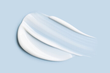 Close-up of cosmetic cream smear, smooth and shiny texture, blue background