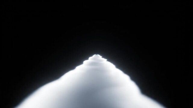 A bright white light shines from the top of a conical shape against a dark background.