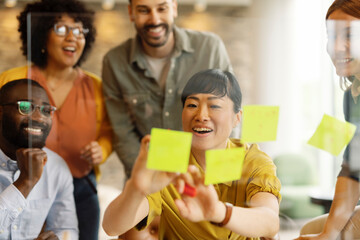 Diverse team collaborating in an office setting with sticky notes during a brainstorming session