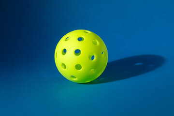 Close-up on a Pickle Ball isolated on blue background