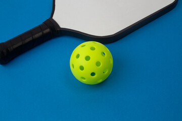 Pickleball Paddle and Ball on a blue background