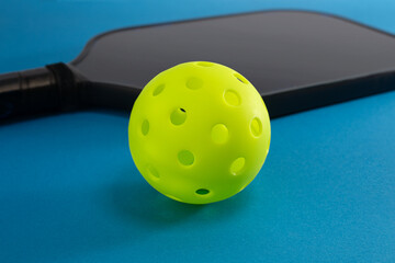 Pickleball Paddle and Ball on a blue background
