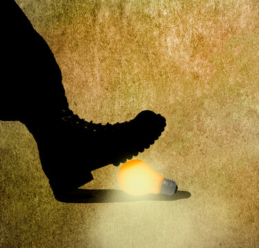 Boot crushing glowing light bulb symbolizing destruction of creativity