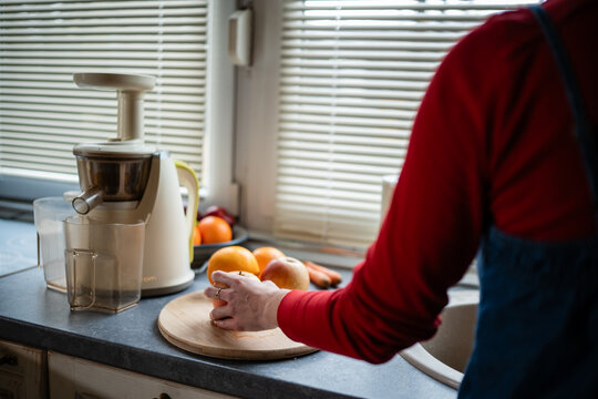 Person making healthy fresh juice with juicer