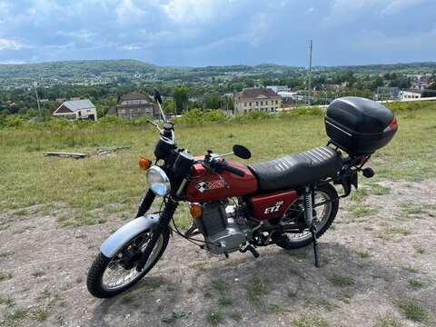 Vintage Motorcycle MZ ETZ 250 parked on a Gravel Road in Forest Landscape